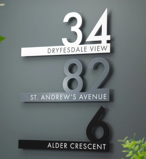 Three floating house signs in white, grey and black